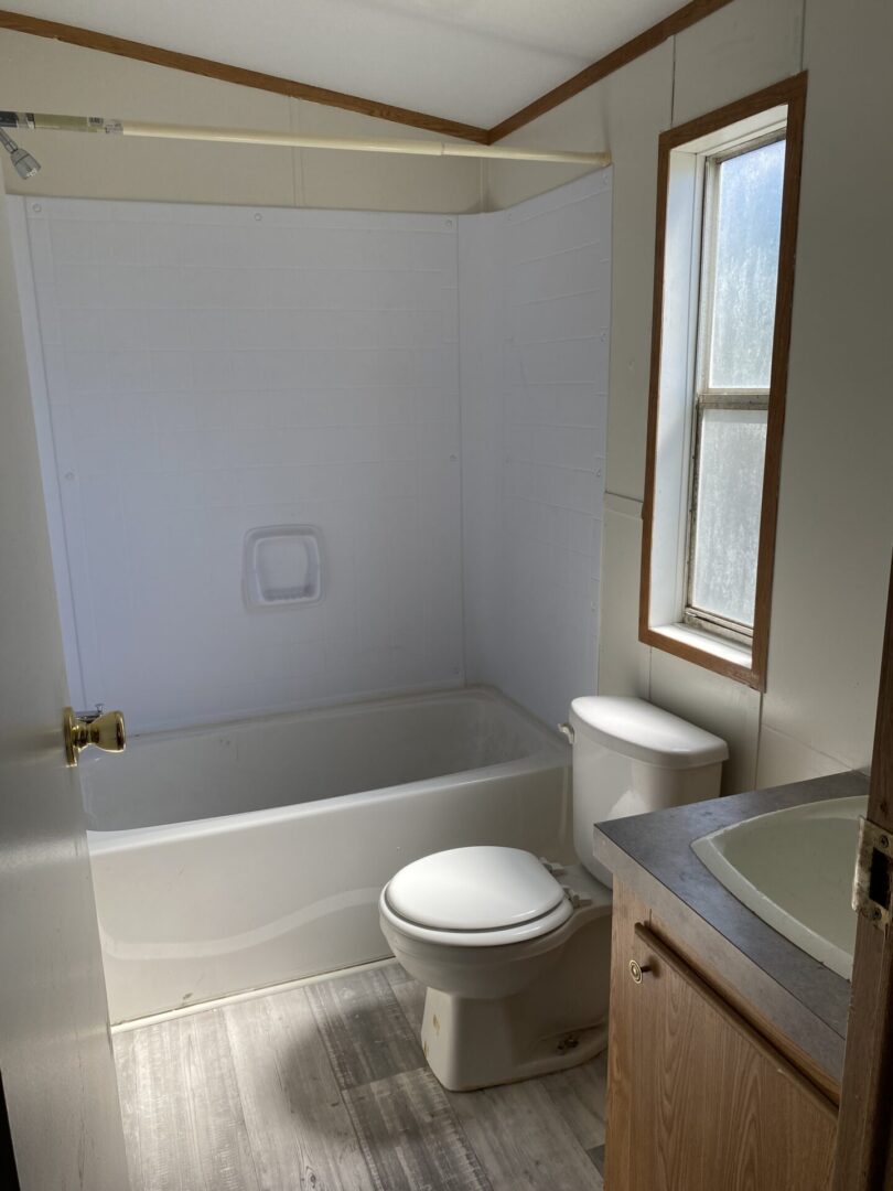 A Guest Bathroom With White Color Tub