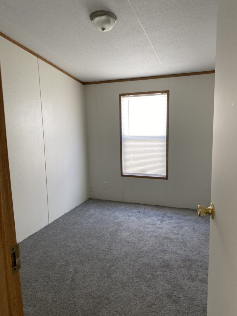An Empty Middle Bedroom With White Walls
